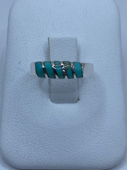 Anillo de plata con ópalo de fuego azul cielo engastado en la mano de una mujer