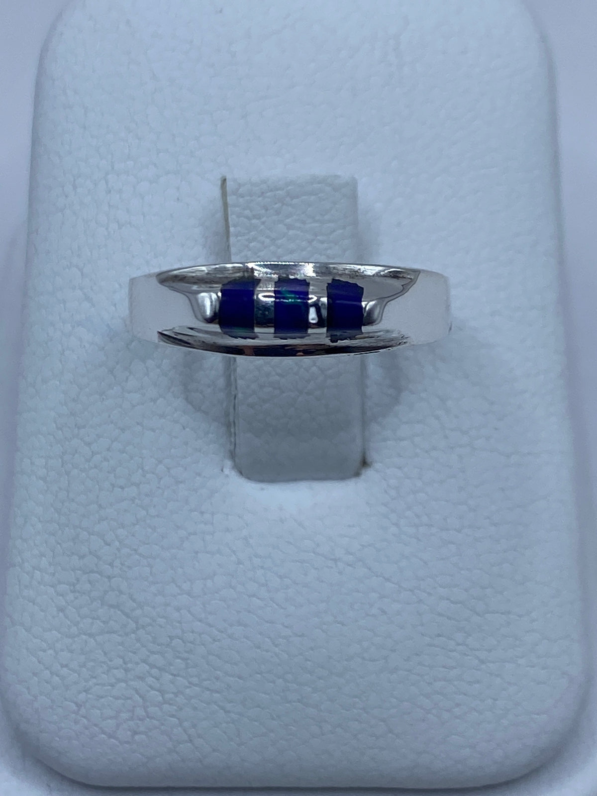 Anillo de plata 925 con piedra azul engastada en talla 7, visto de frente sobre estuche blanco