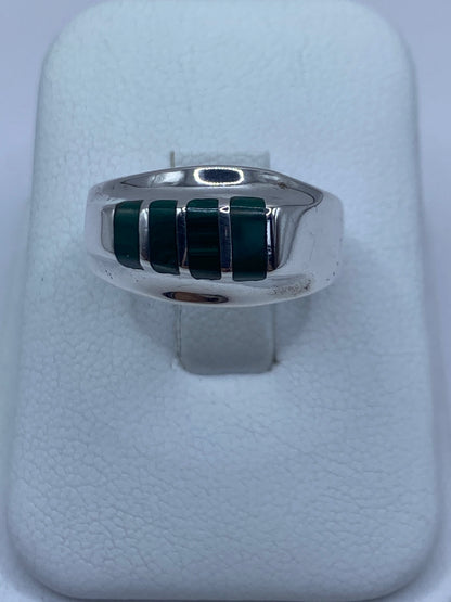 Anillo de plata 925 con malaquita verde engastada en la mano de una persona