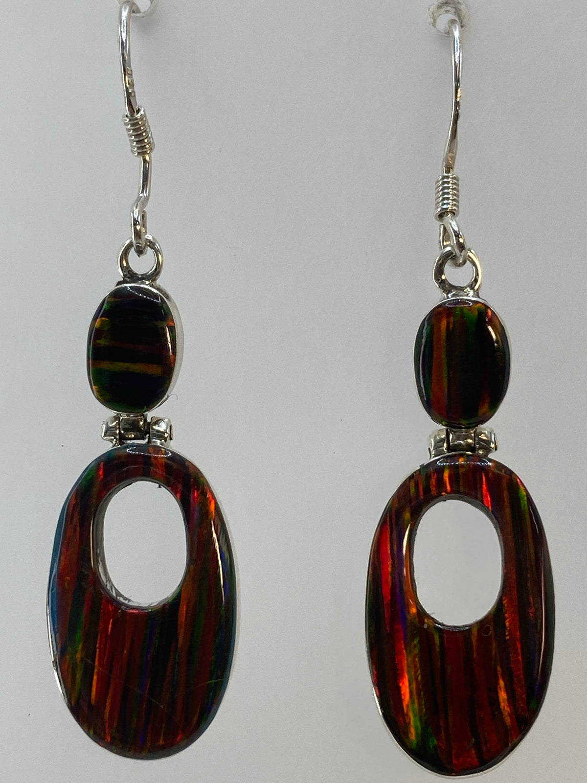 Aretes colgando, mostrando la altura de 4.2 cm y el brillo del ópalo