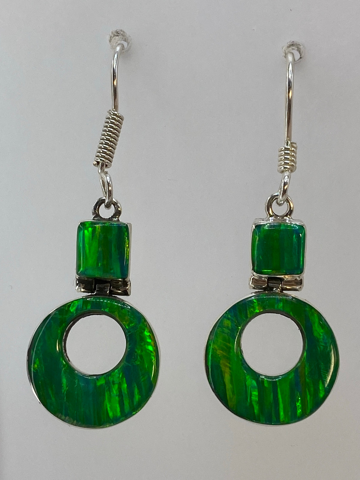 Aretes de plata con ópalo de fuego verde limón colgando de gancho de plata