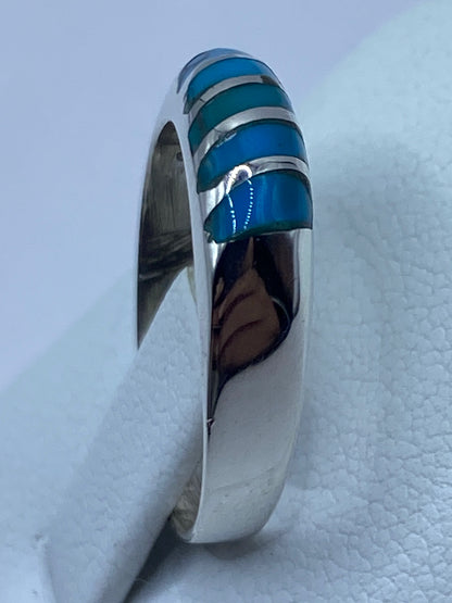 Anillo en la mano de una persona, turquesa brillando al luz