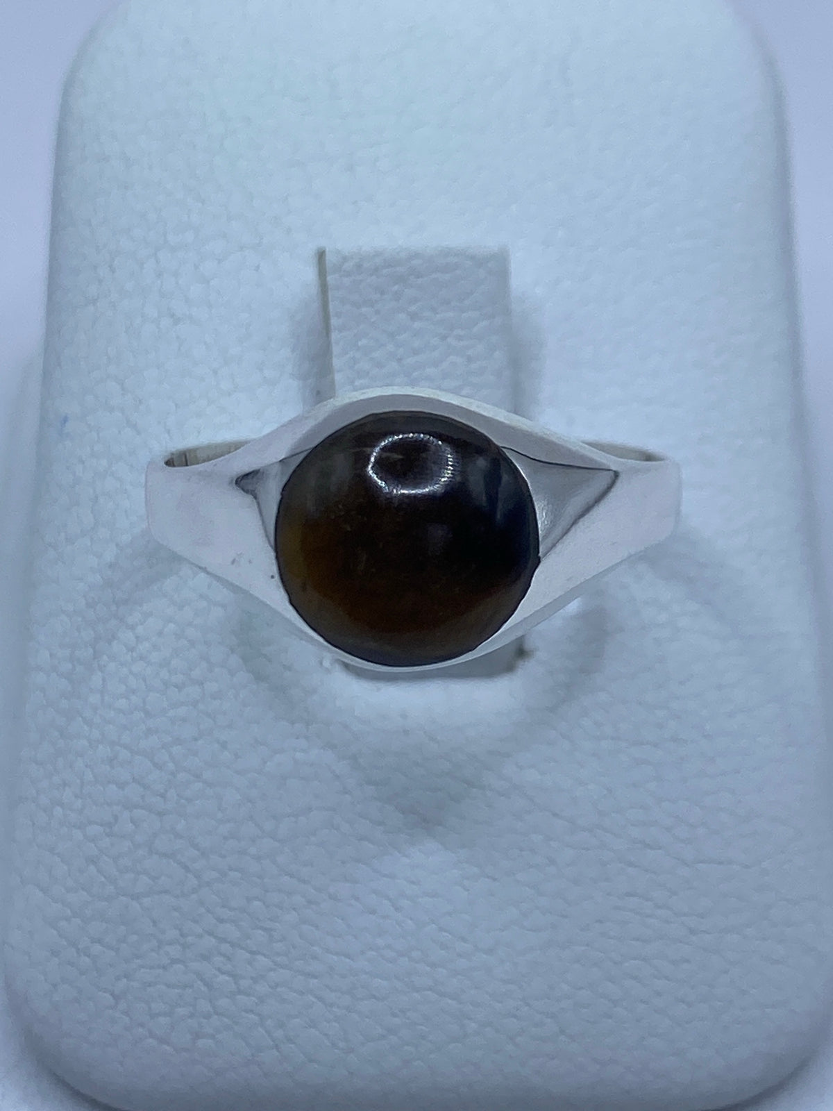 Anillo de plata 925 con Ojo de Tigre café engastado en la mano de una persona