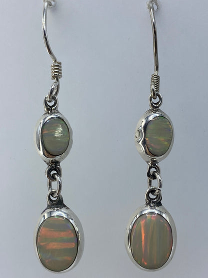 Par de aretes de ópalo de fuego al lado de escala de medida, largo 4.7 cm