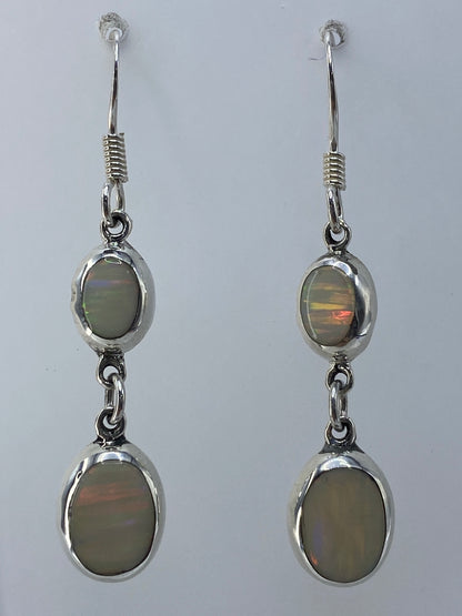 Par de aretes de plata con ópalo de fuego multicolor que refleja tonos verdes, dorados y rojos
