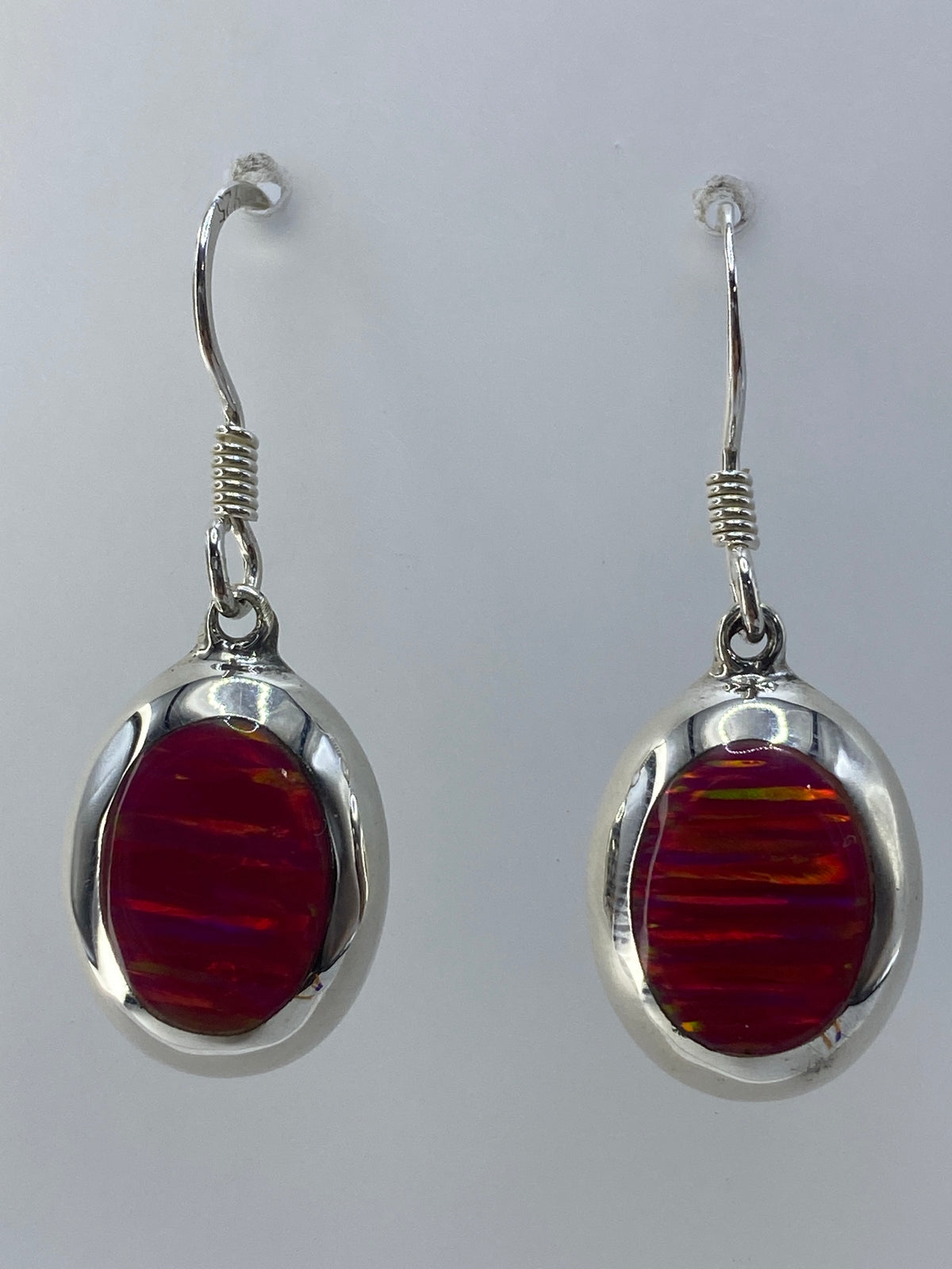 Aretes colgantes de plata 925 con ópalo de fuego rosa, mostrando la iridiscencia de las gemas