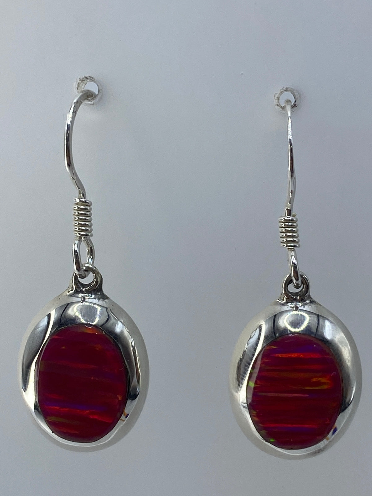 Detalle de la gema de ópalo rosa con reflejos de fuego y el engaste de plata a mano