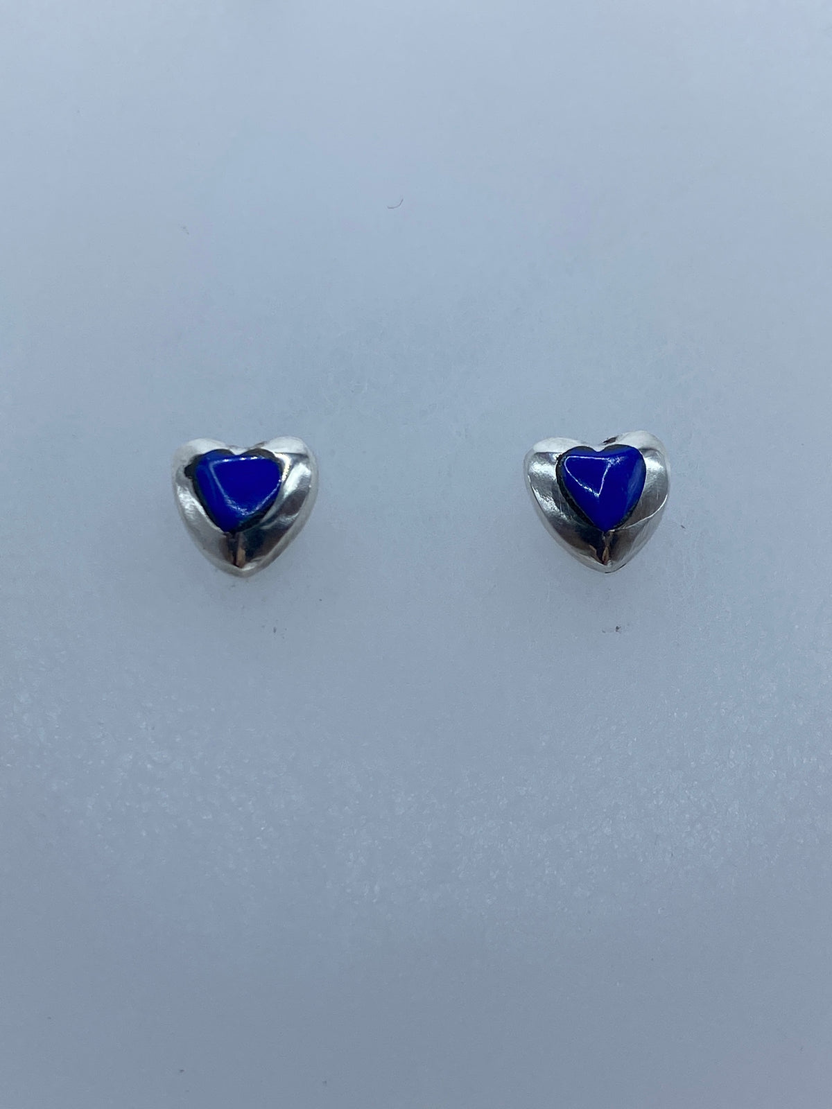 Detalle lateral de un arete de plata con engaste de coral azul