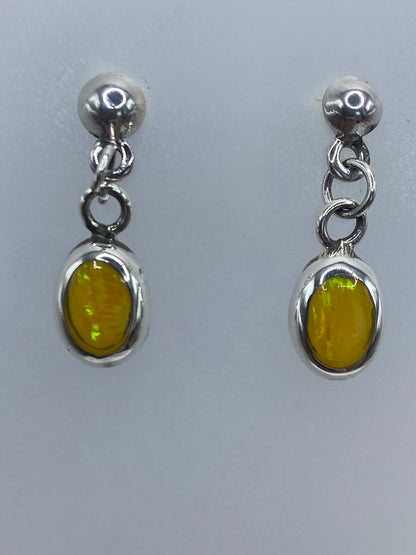 Aretes de ópalo sobre escala de medidas, mostrando tamaño de 2 cm de largo