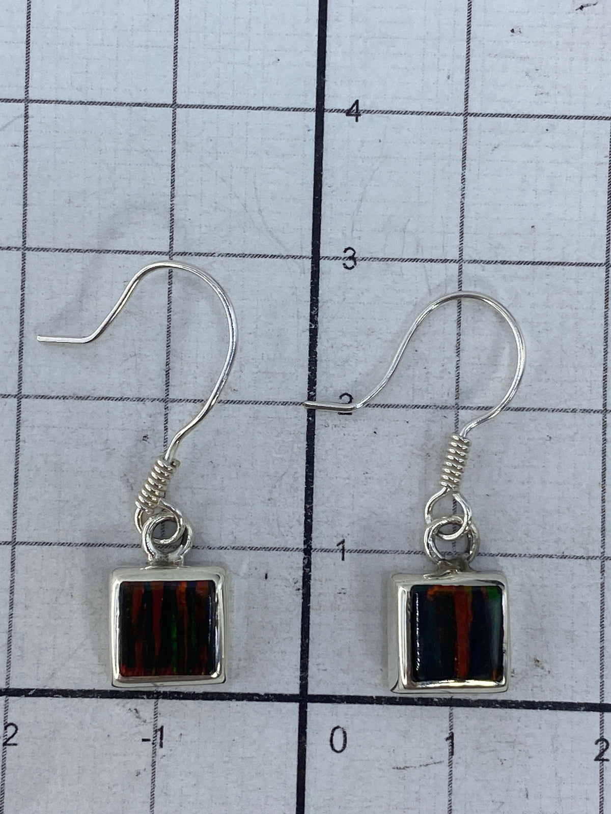 Aretes sobre escala de medidas mostrando 2.9 cm de largo, con cierre de gancho de plata