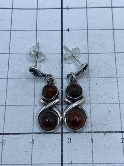 Aretes sobre regla de centímetros mostrando largo de 2.9 cm