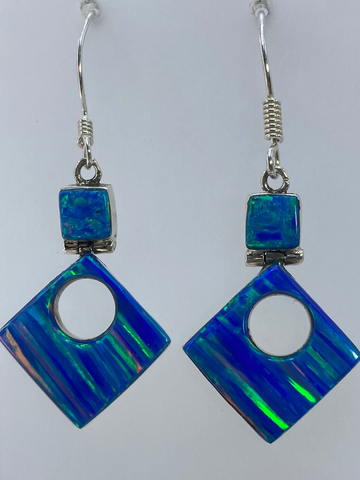 Aretes sobre escala de medidas mostrando largo de 4.3 cm
