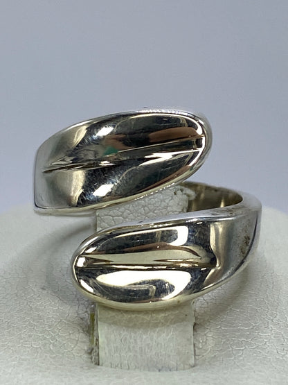 Anillo de plata cartoneado minimalista en la mano de una mujer, vista frontal del volumen 3D