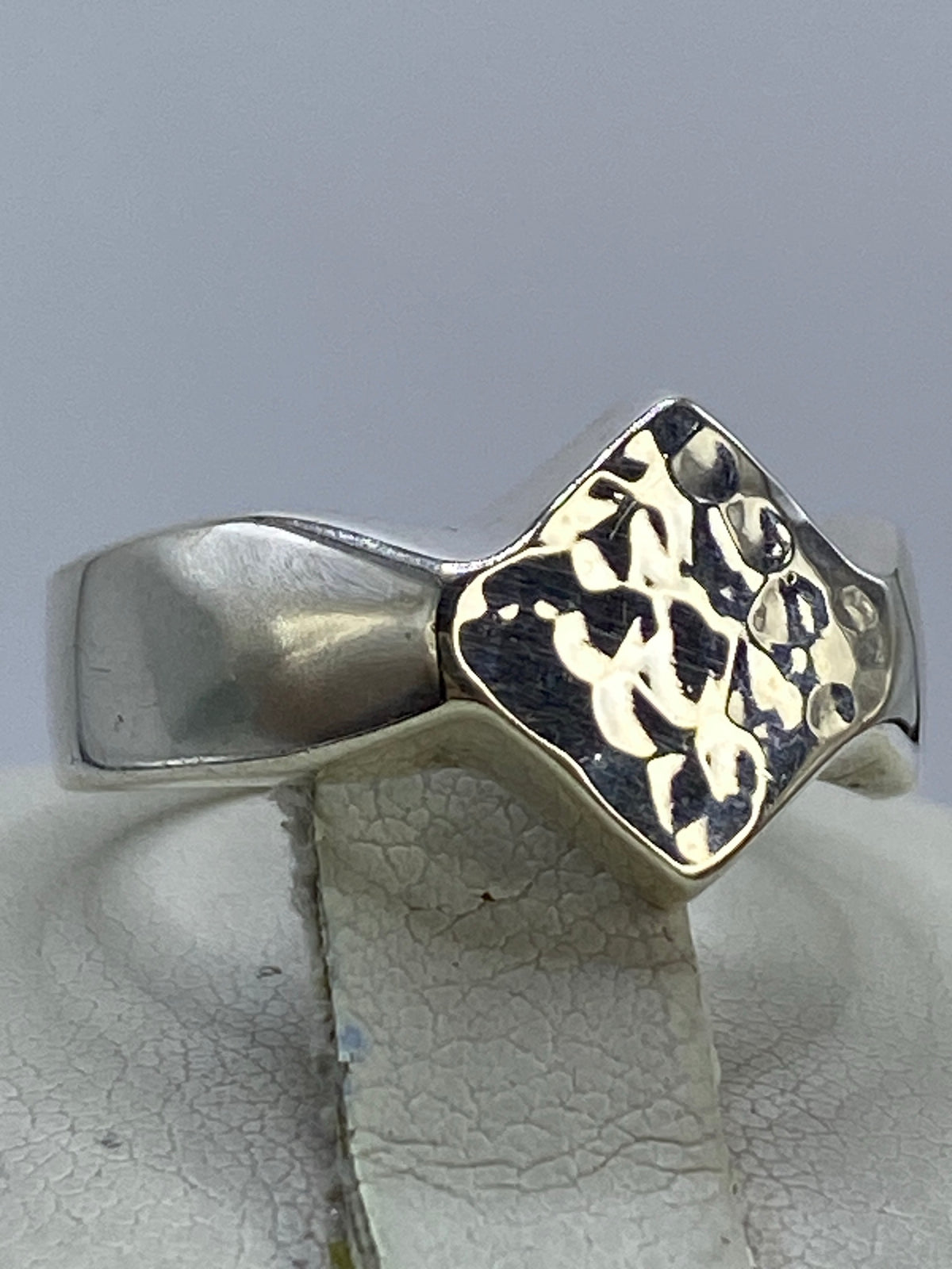 Vista lateral del anillo de plata repujada mostrando el volumen del diseño