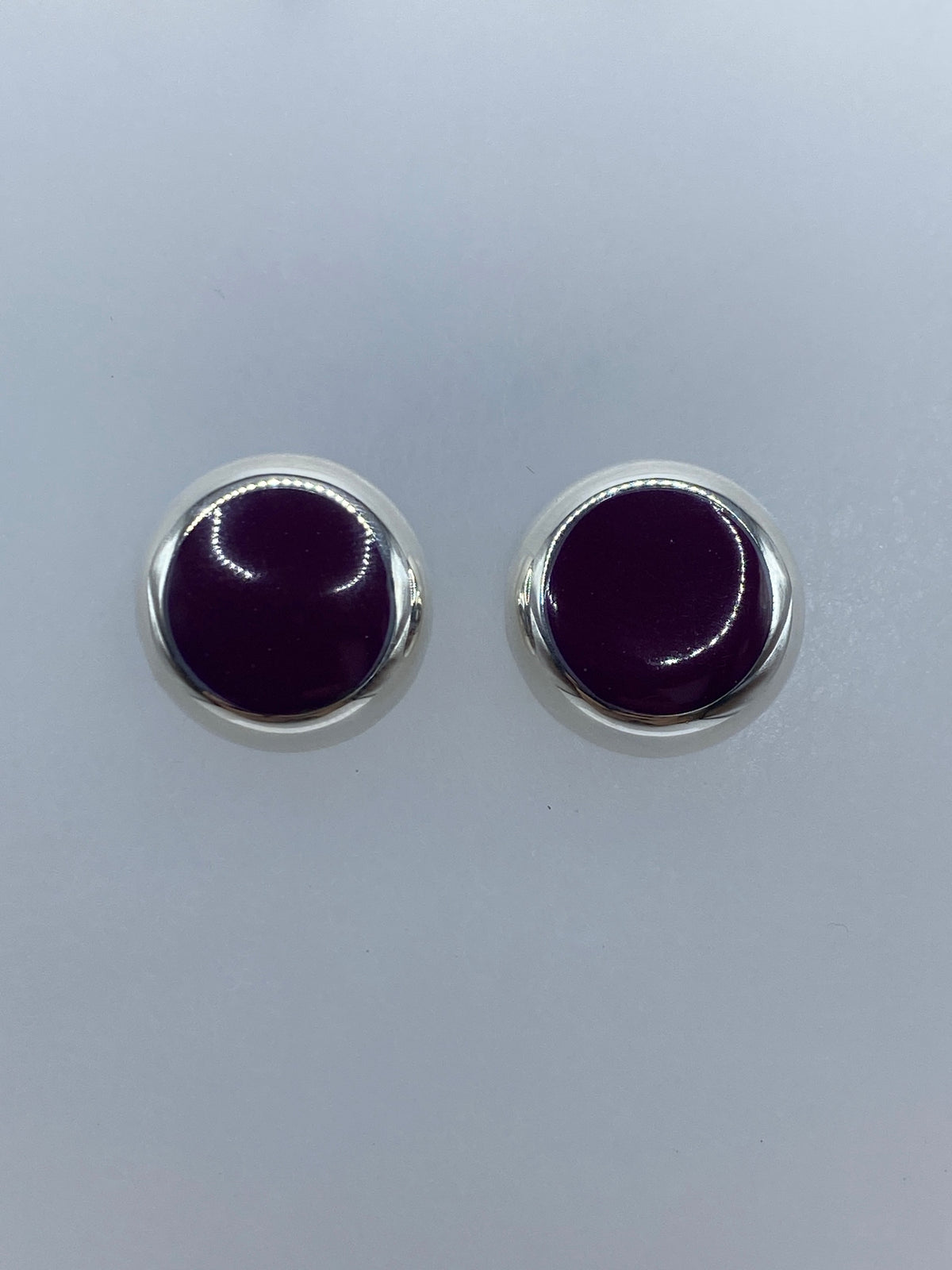 Par de aretes de plata con piedra morada redonda, vista frontal