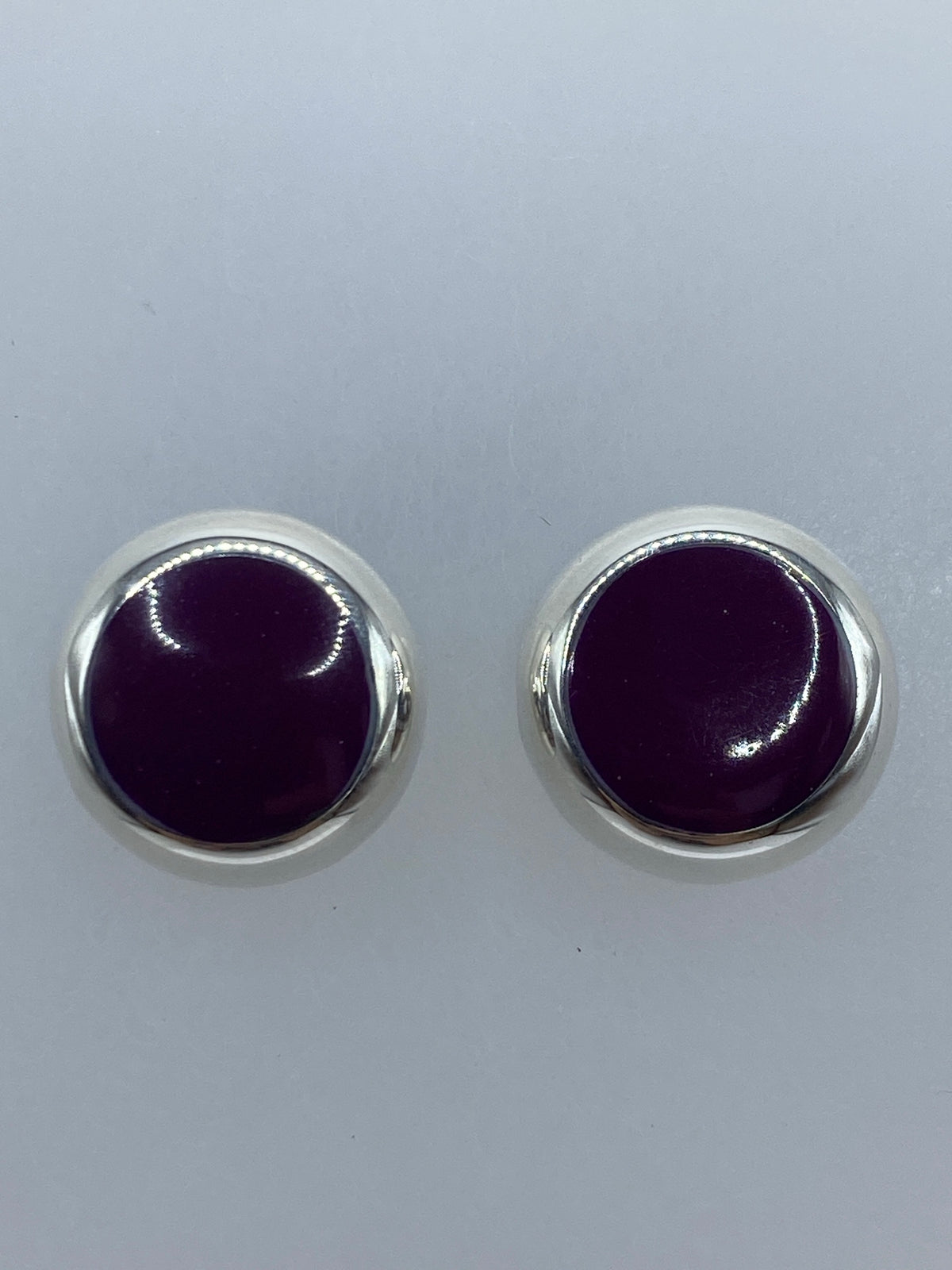 Aretes sobre regla de centímetros mostrando tamaño compacto 1.4 × 1.4 cm