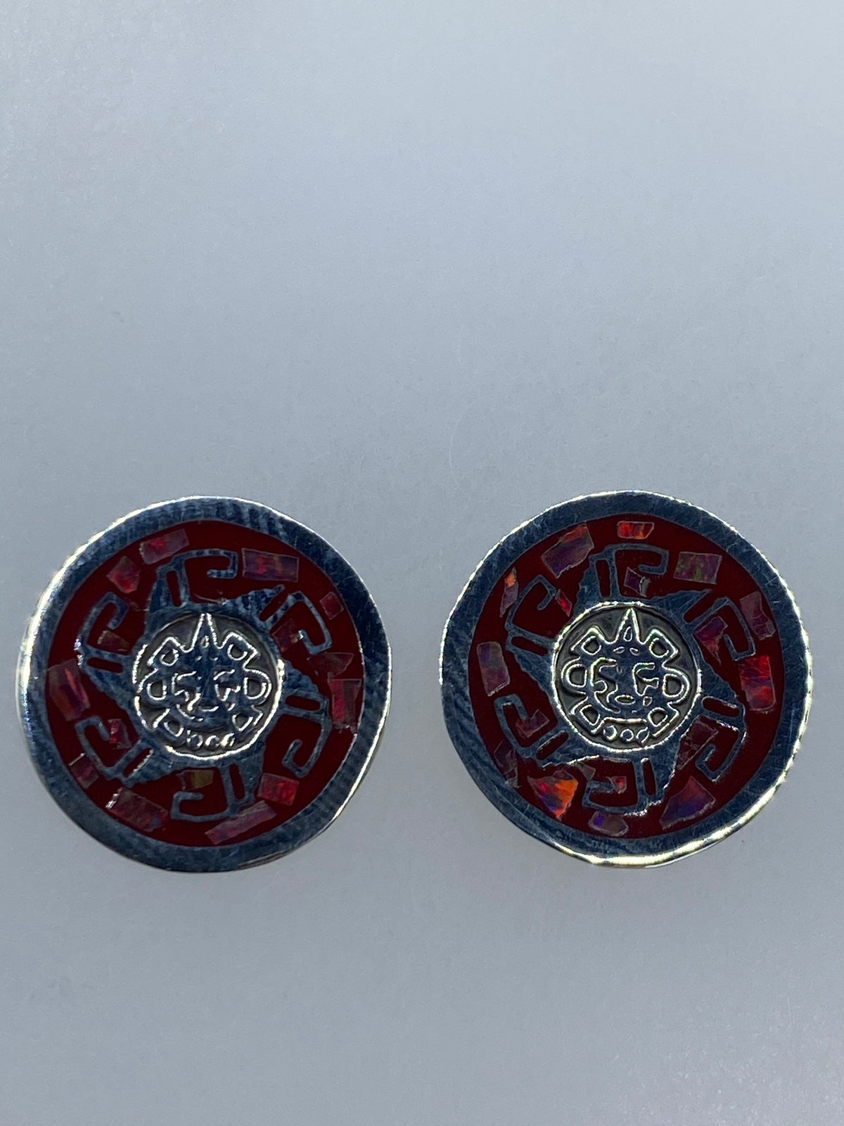 Aretes de ópalo rojo vistos desde el frente mostrando el juego de luz