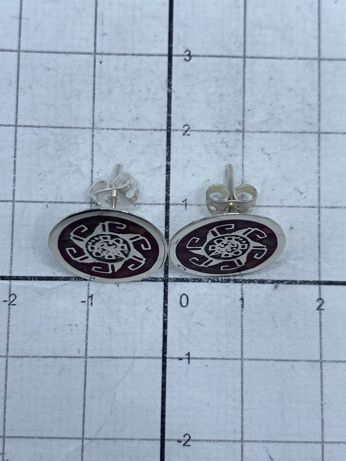 Aretes de plata y ópalo de fuego sobre fondo neutro