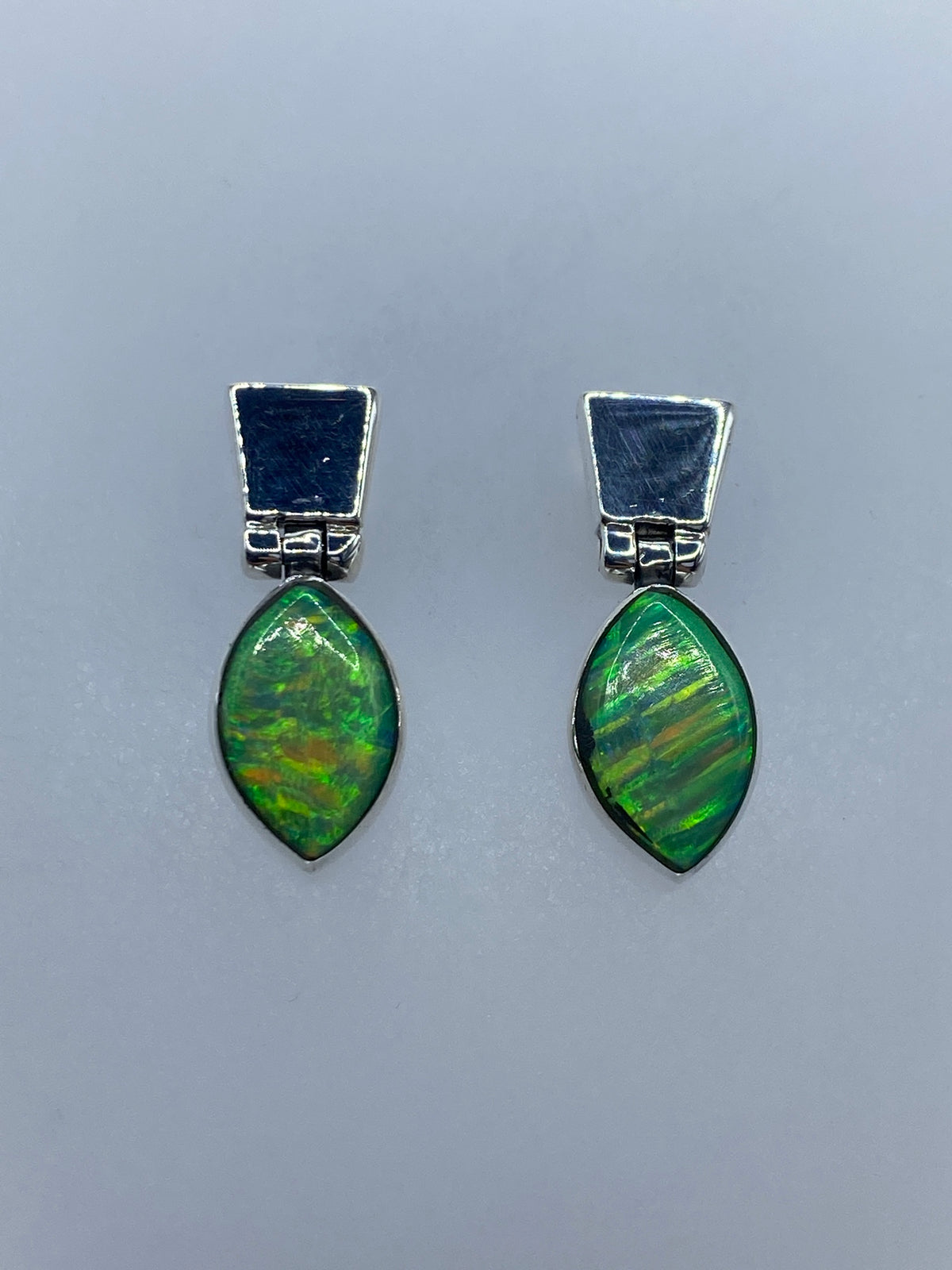 Aretes vistos de frente mostrando el tamaño de 2.2 cm y el detalle del engaste