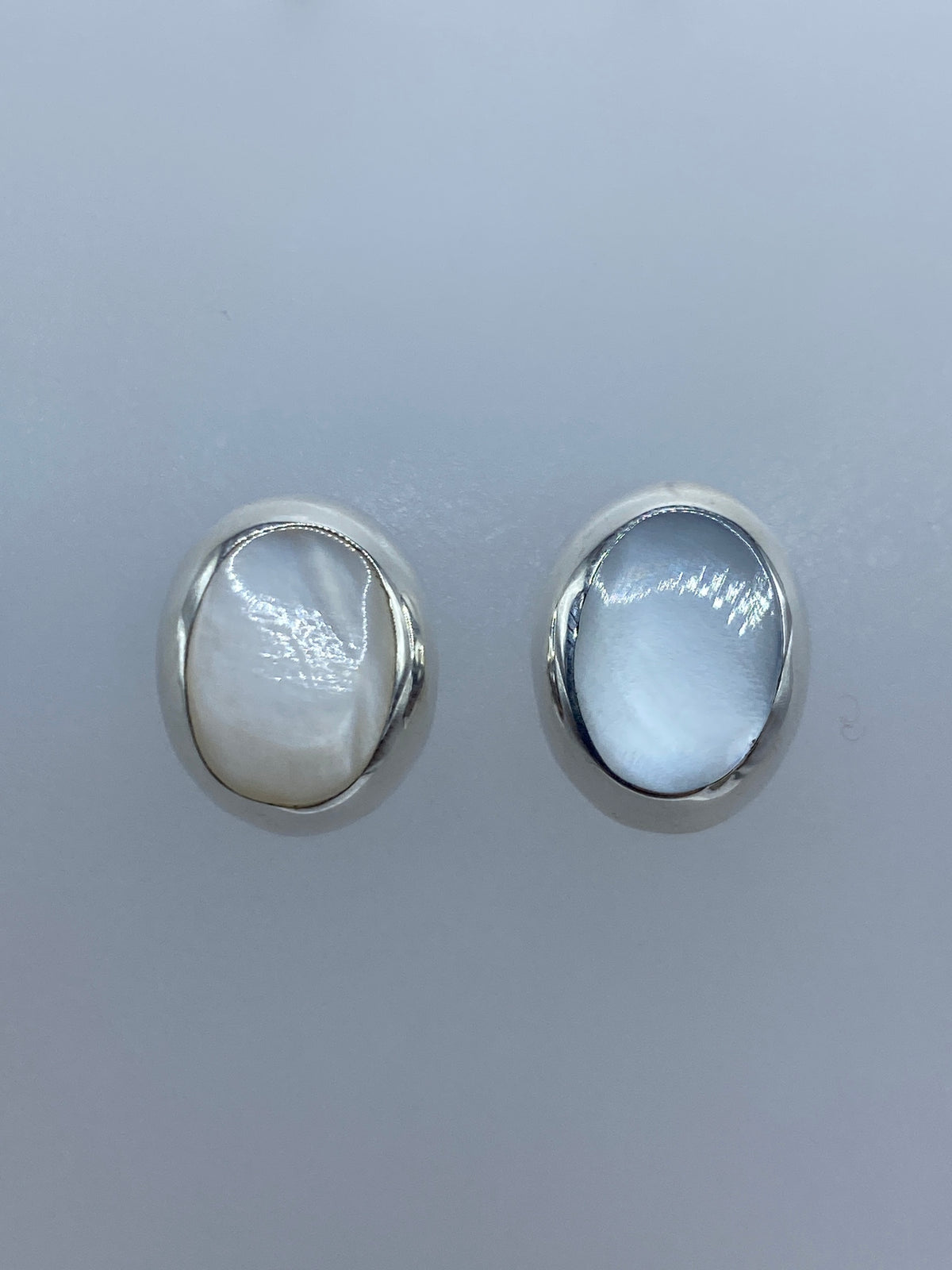 Par de aretes de plata 925 con madre perla blanca, vista frontal mostrando el brillo nacarado
