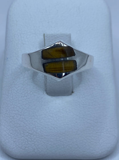 Anillo de plata 925 con ojo de tigre café en la mano de una persona