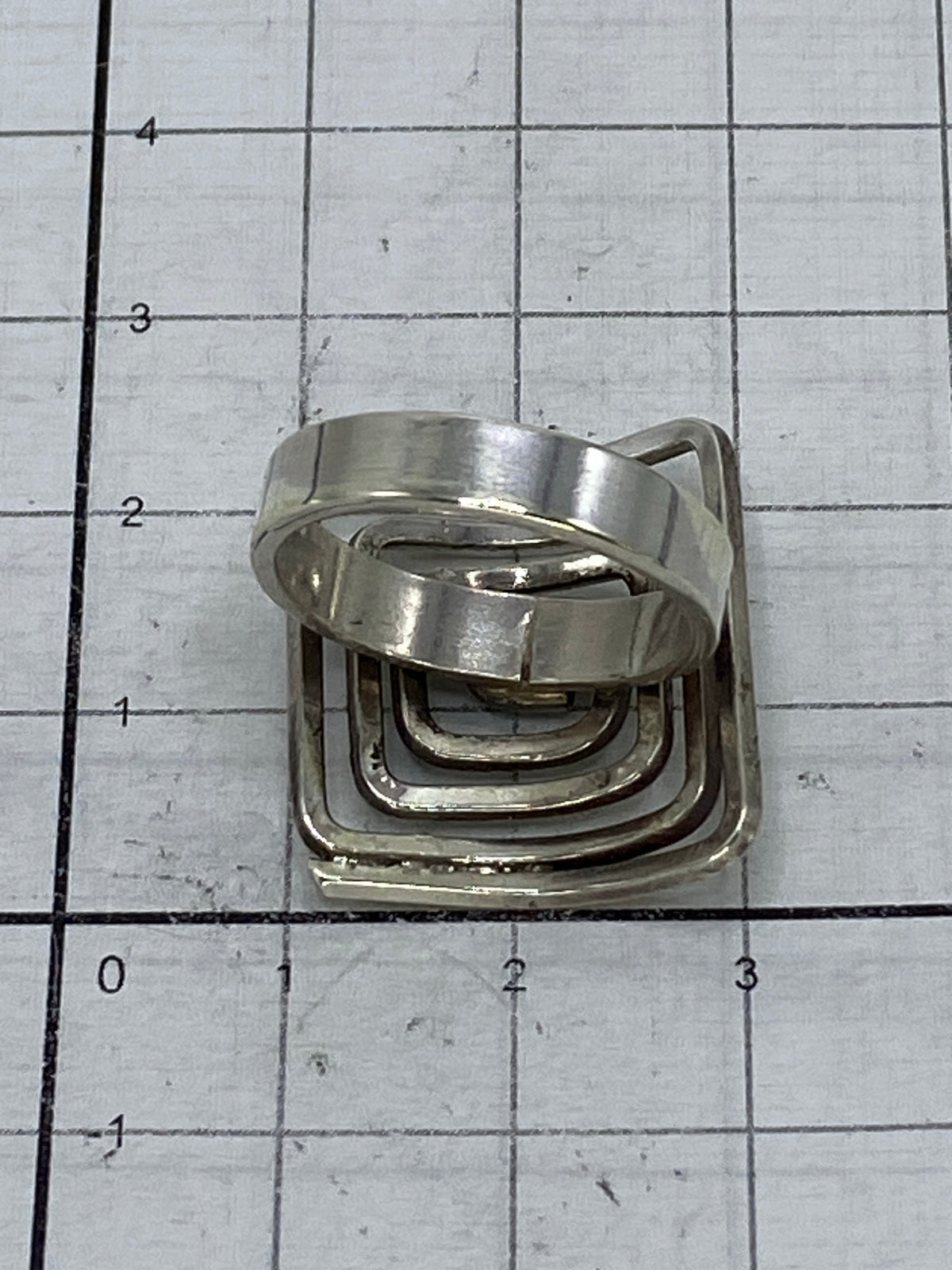 Anillo sobre fondo blanco mostrando la geometría en espiral del diseño