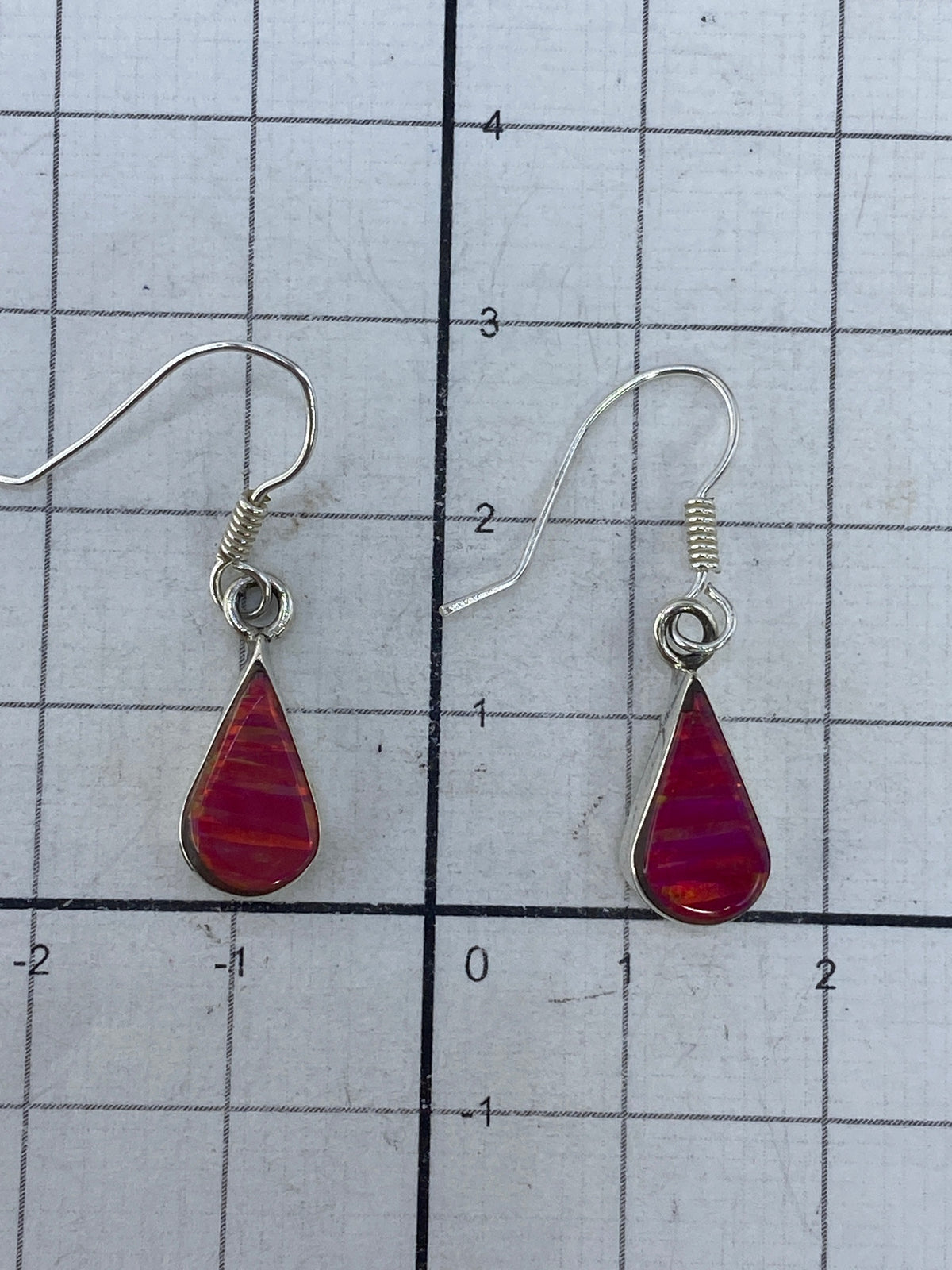 Aretes sobre regla de centímetros mostrando largo de 2.9 cm