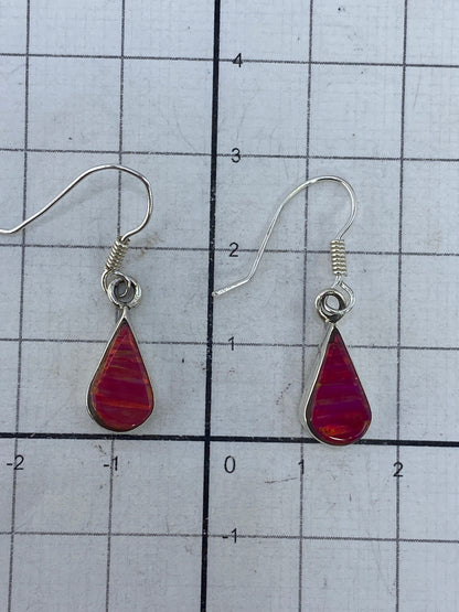 Aretes sobre regla de centímetros mostrando largo de 2.9 cm