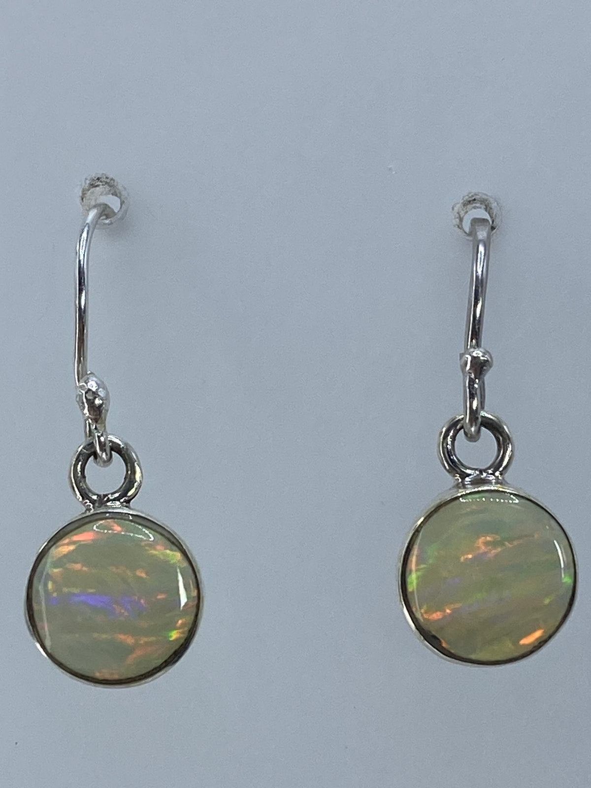 Detalle del ópalo multicolor mostrando los destellos naranjas y verdes en la luz