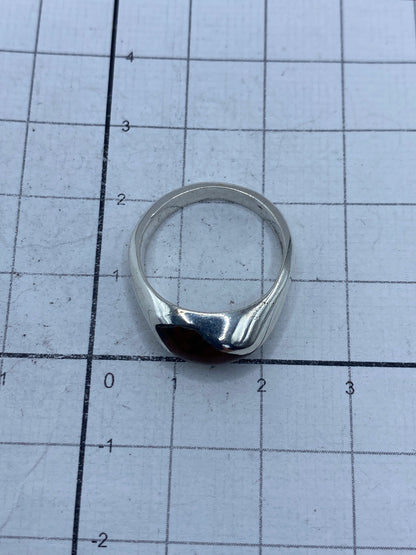 Anillo puesto en dedo, piedra cafe en primer plano, acabado minimalista