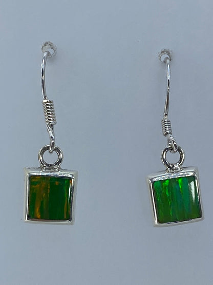 Par de aretes de plata 925 con ópalo de fuego verde limón, luz natural mostrando el brillo traslúcido
