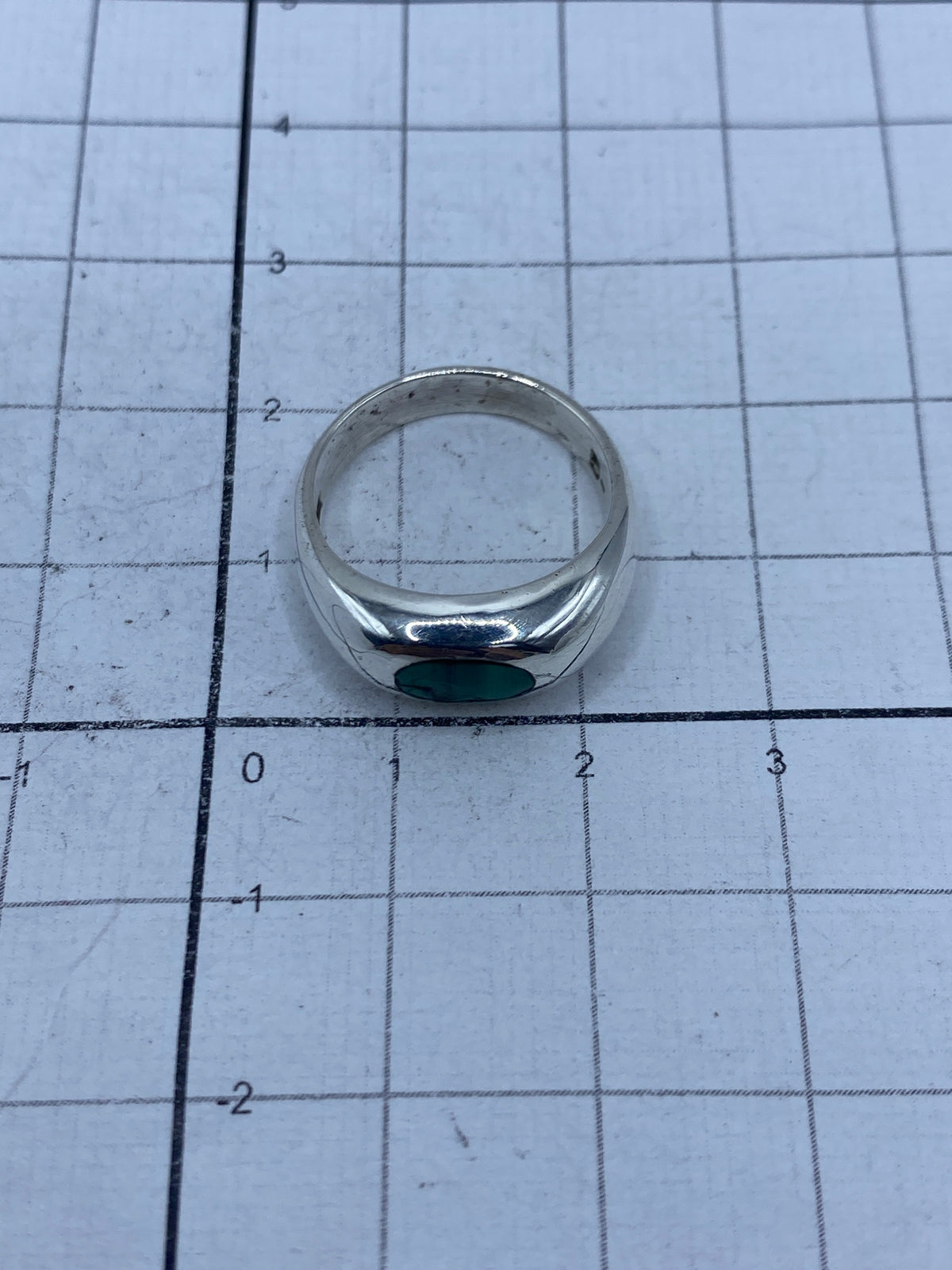 Vista lateral del anillo de plata con malaquita, perfilando la banda ancha y pulida