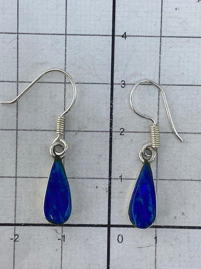 Aretes sobre regla de medición mostrando 3 cm de largo, con gancho de plata