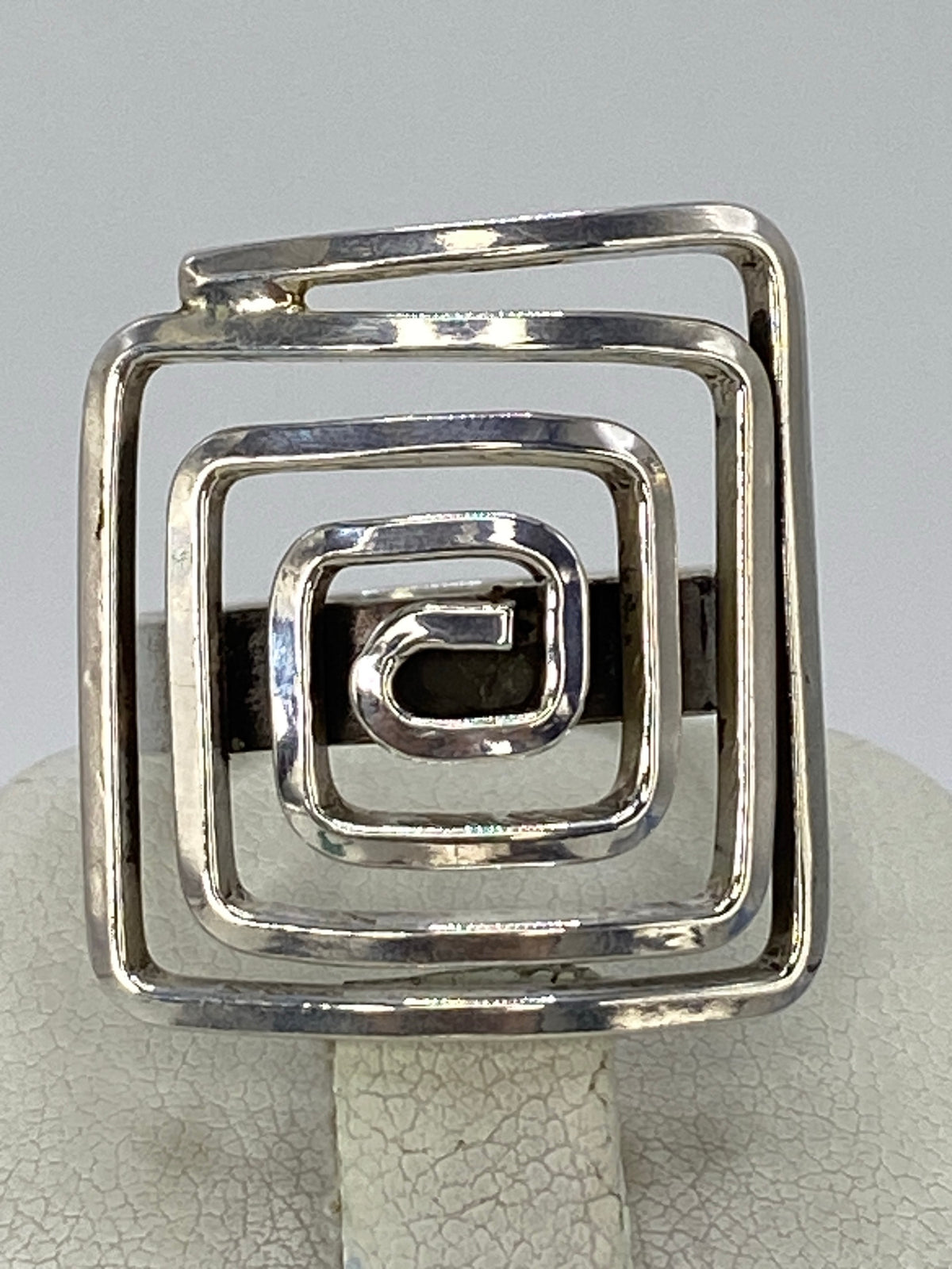 Anillo de plata calado con diseño geométrico cuadrado anidado en la mano