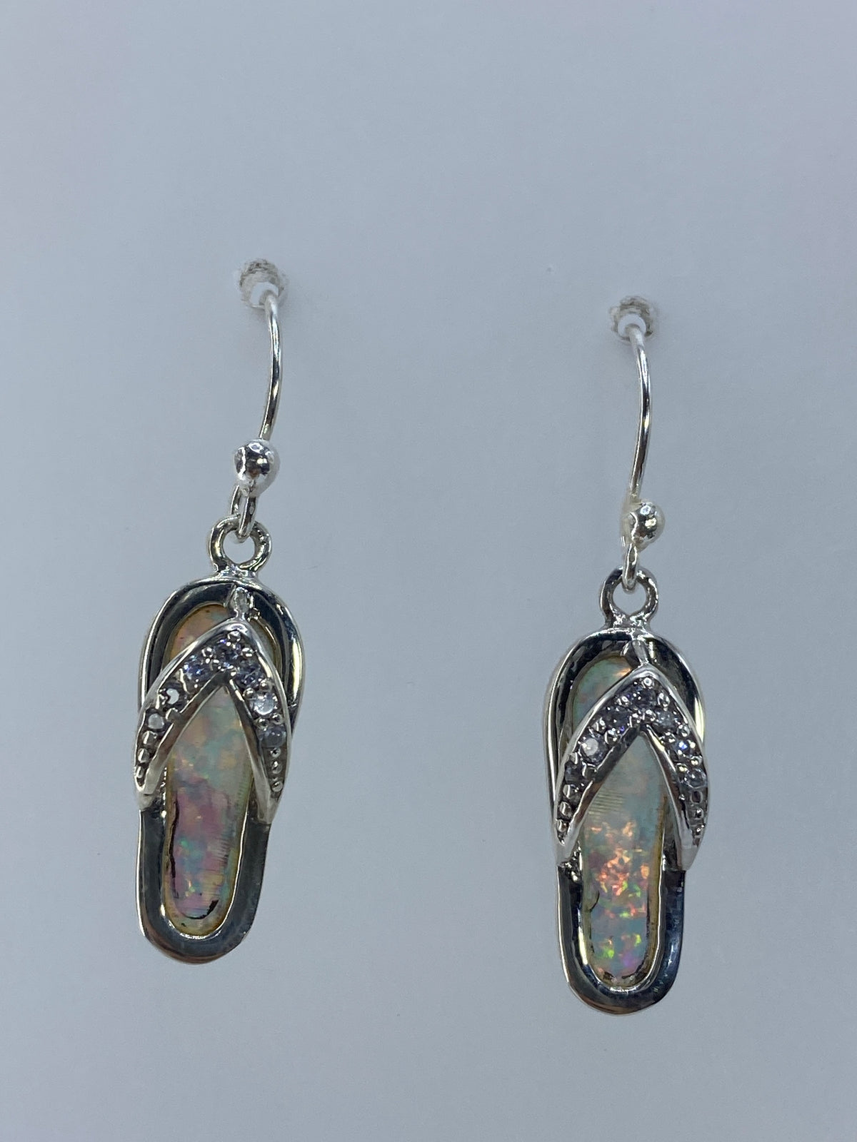 Arete individual de ópalo de fuego en plata — detalle del engaste a mano