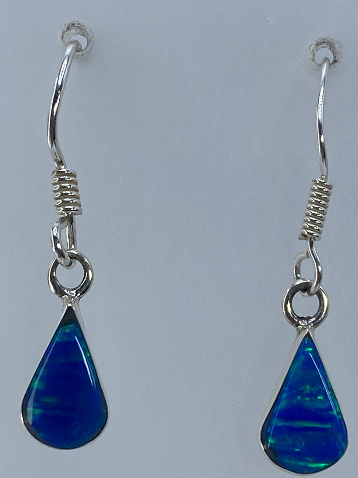 Aretes en uso sobre oreja, mostrando el largo de 3 cm y la elegancia del engaste