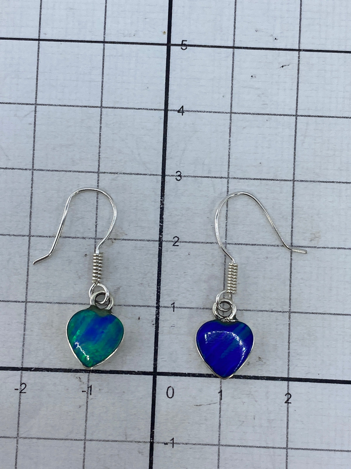 Aretes de plata junto a báscula digital marcando 1.26 gramos