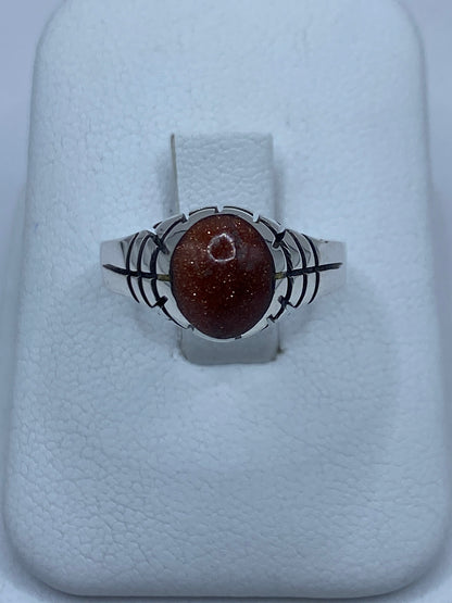 Anillo de plata 925 con piedra café engastada a mano, vista superior sobre fondo blanco