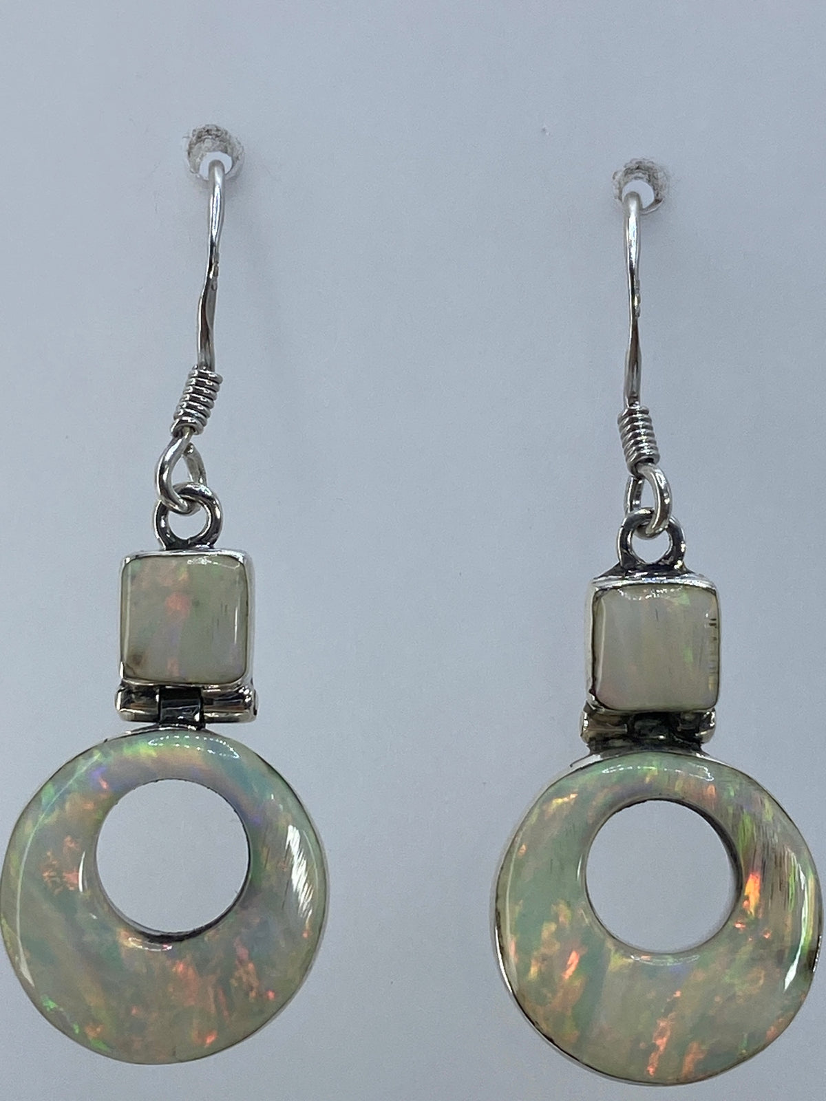 Aretes de ópalo de fuego mostrando los destellos rojos y naranjas de la piedra