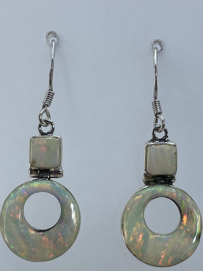 Aretes de ópalo de fuego mostrando los destellos rojos y naranjas de la piedra