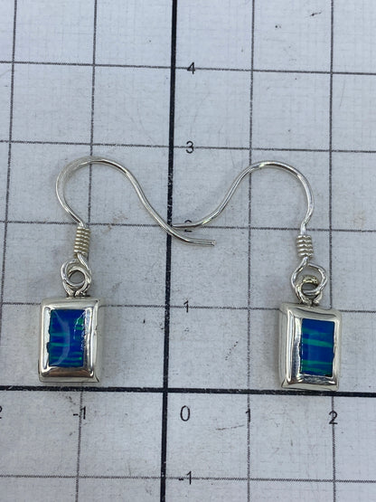 Aretes sobre fondo blanco con gancho de plata, vista frontal del Quinto