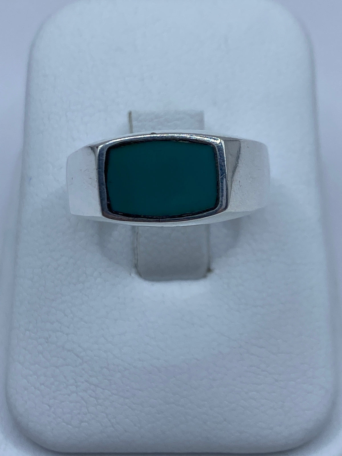 Anillo de plata con turquesa azul engastada, visto de frente en exhibidor