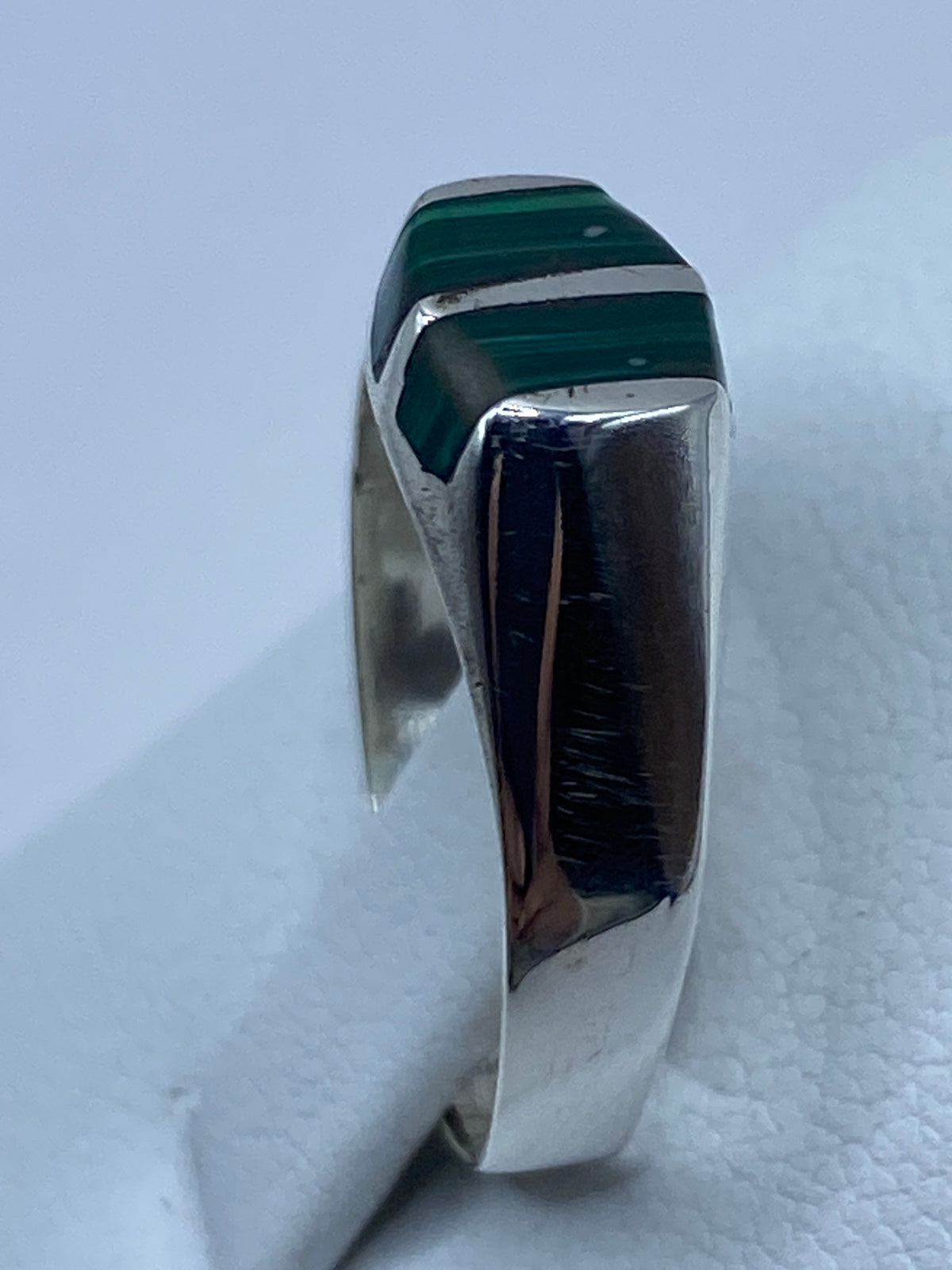Anillo de malaquita puesto en dedo, mostrando el verde profundo de la piedra