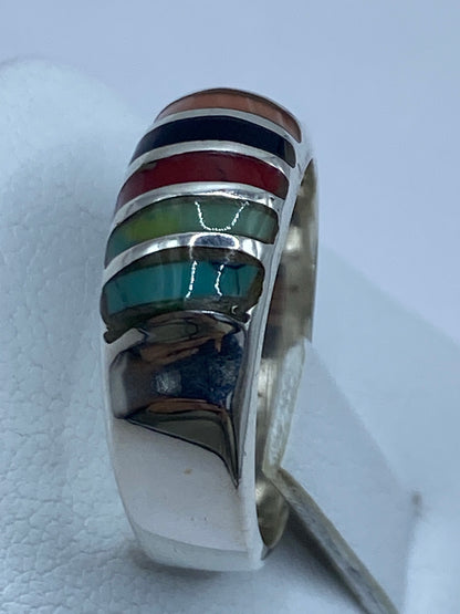 Detalle de las tres piedras: turquesa, coral y ónix en el anillo de plata