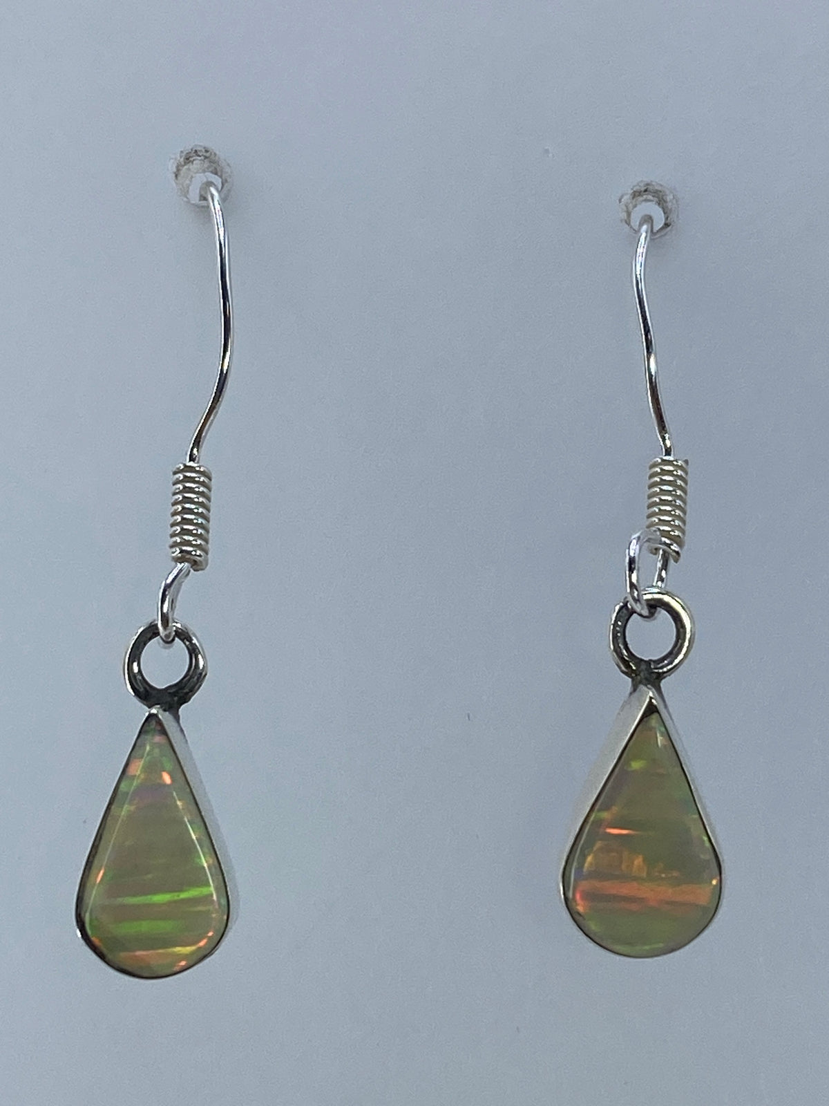 Aretes de plata con ópalo de fuego multicolor de 3 cm, mostrando destellos naranja, rojo y amarillo