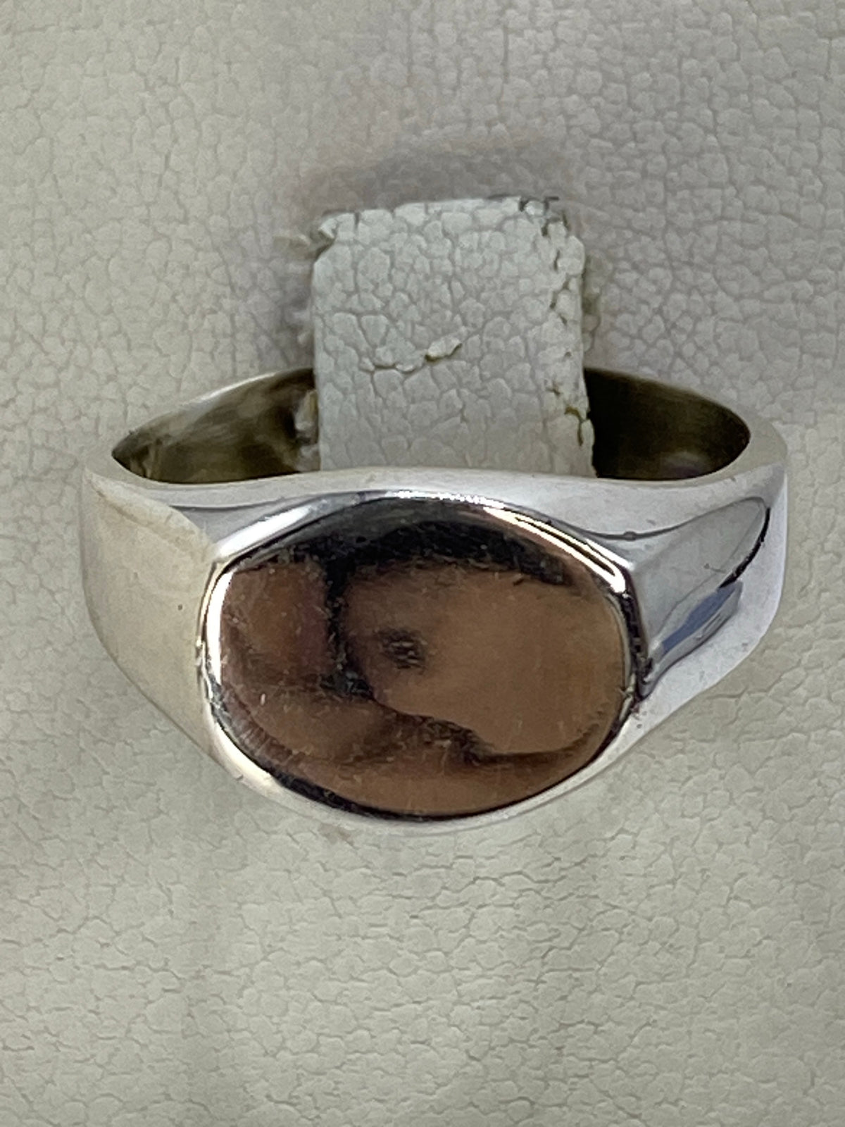 Anillo de plata repujado minimalista en la mano de una mujer, mostrando el relieve artesanal