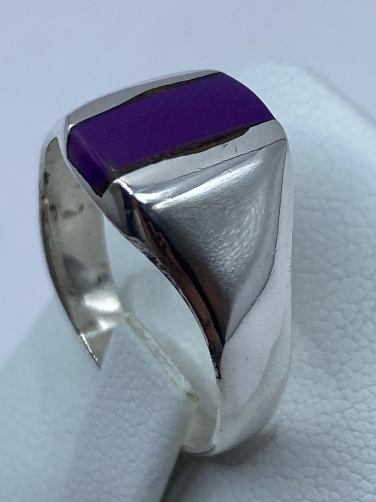 Anillo en la mano mostrando el brillo de la plata y el color de la piedra