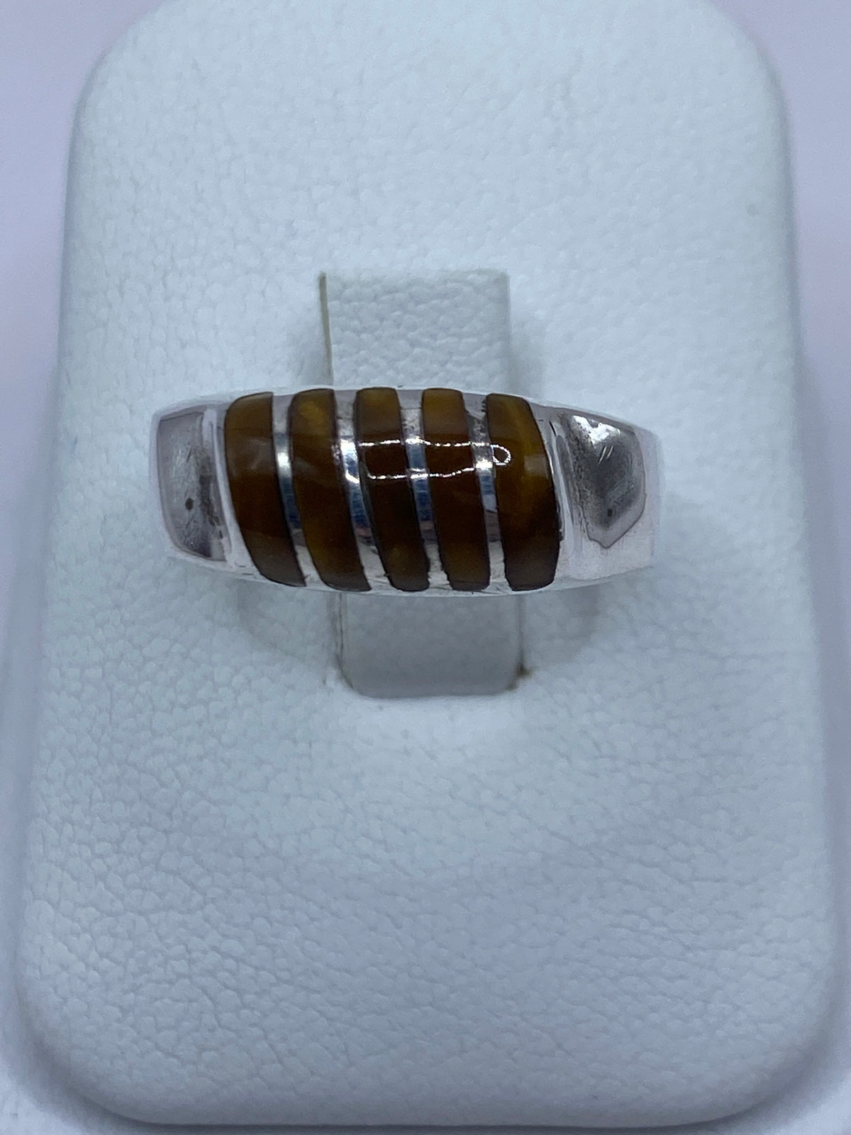 Anillo de plata 925 con Ojo de Tigre café engastado, visto de frente en presentador blanco