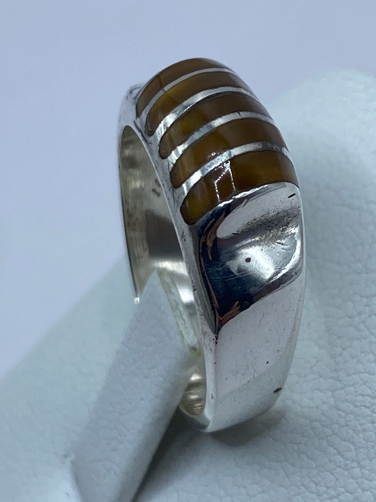 Anillo en dedo mostrando el reflejo natural del Ojo de Tigre bajo luz natural