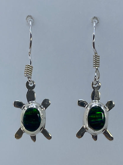 Par de aretes de plata con ópalo de fuego verde, forma de tortuga, sobre fondo gris